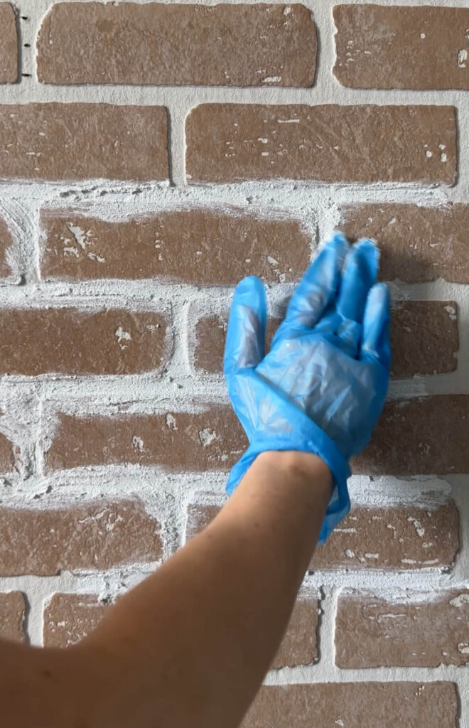 Up close look of a faux brick accent wall demonstrating how to apply the sanded grout. 