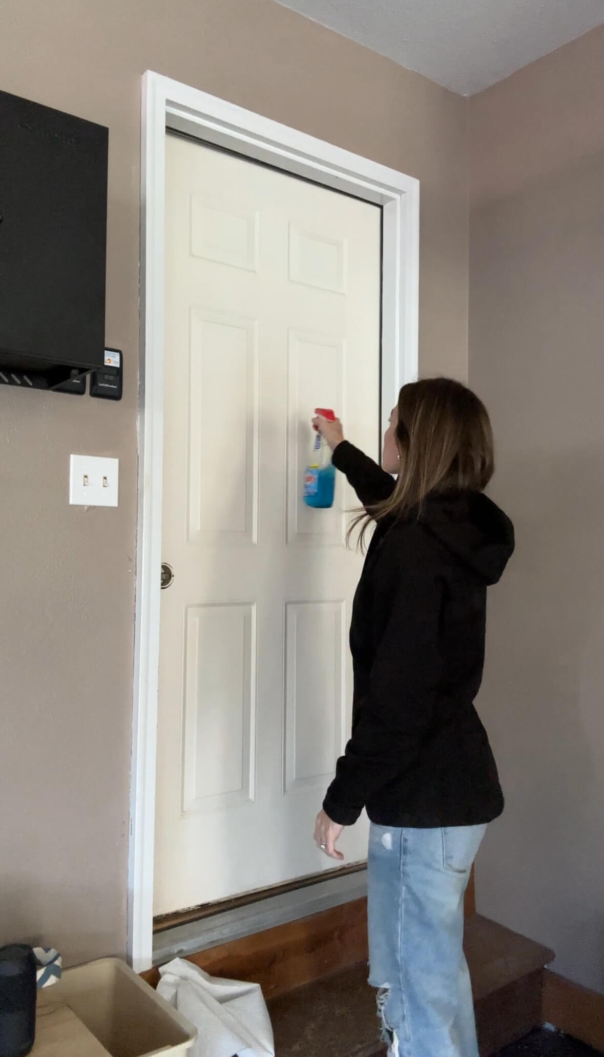 Melissa Tyler prepping her door with cleaner for paint. 