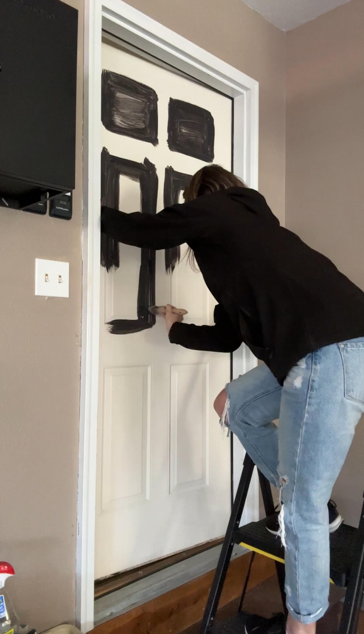 Melissa Tyler painting the insets of her door 