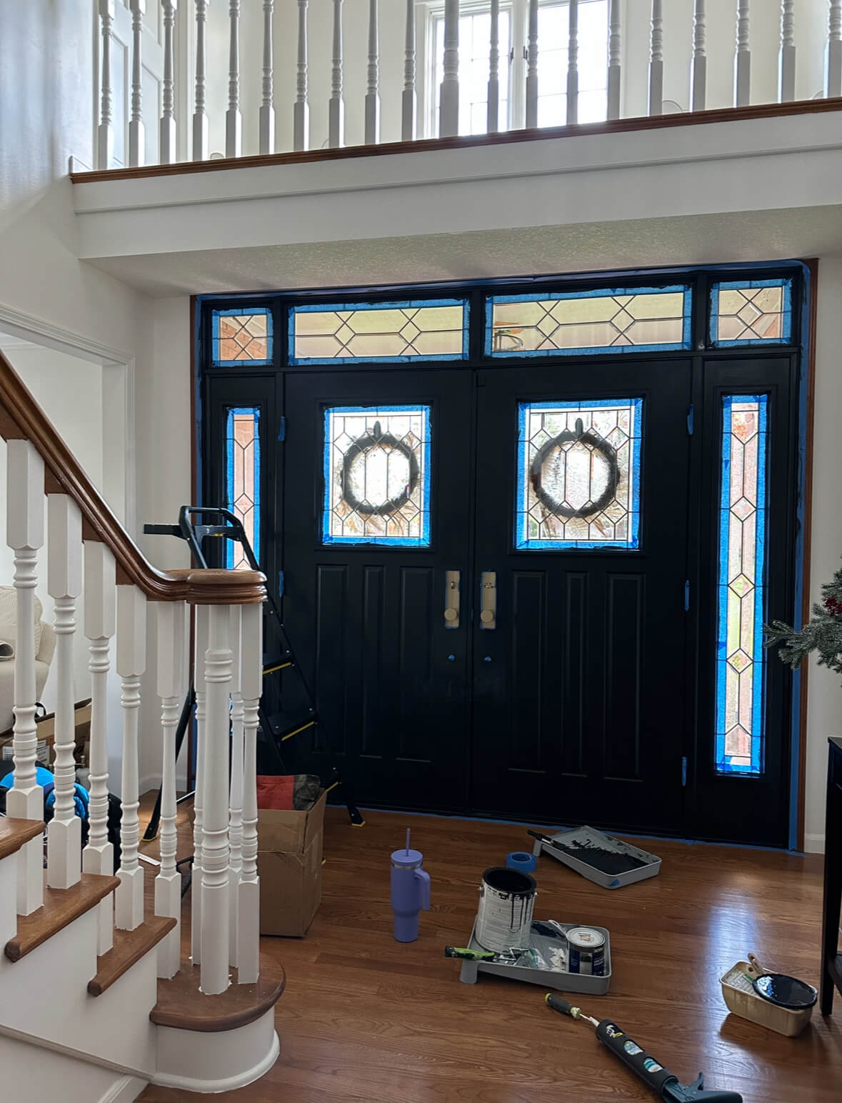 Interior door painted black with blue painters tape surrounding it 