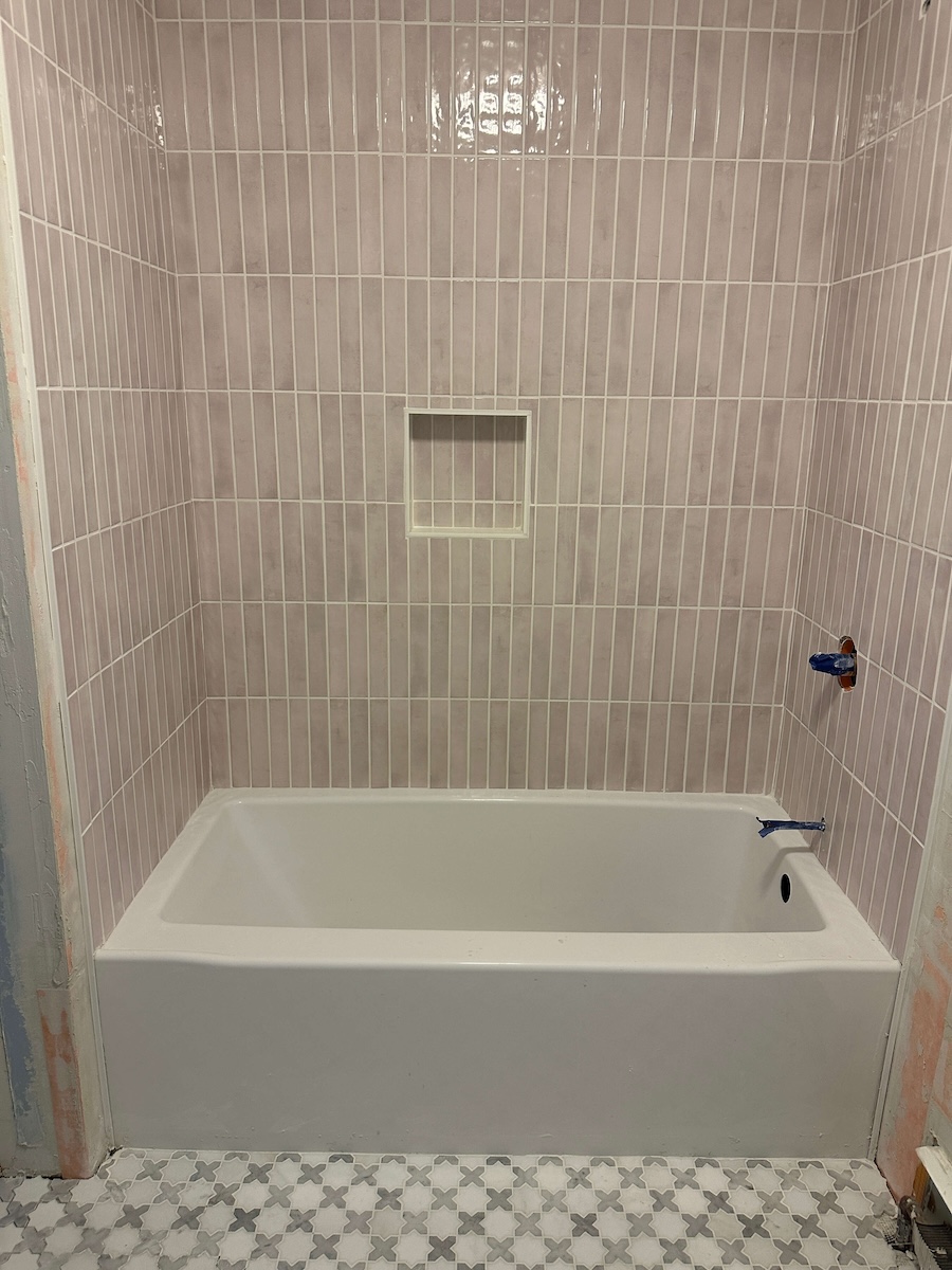 Vertical Tiles installed in the shower. The Tiles are blush and long. 