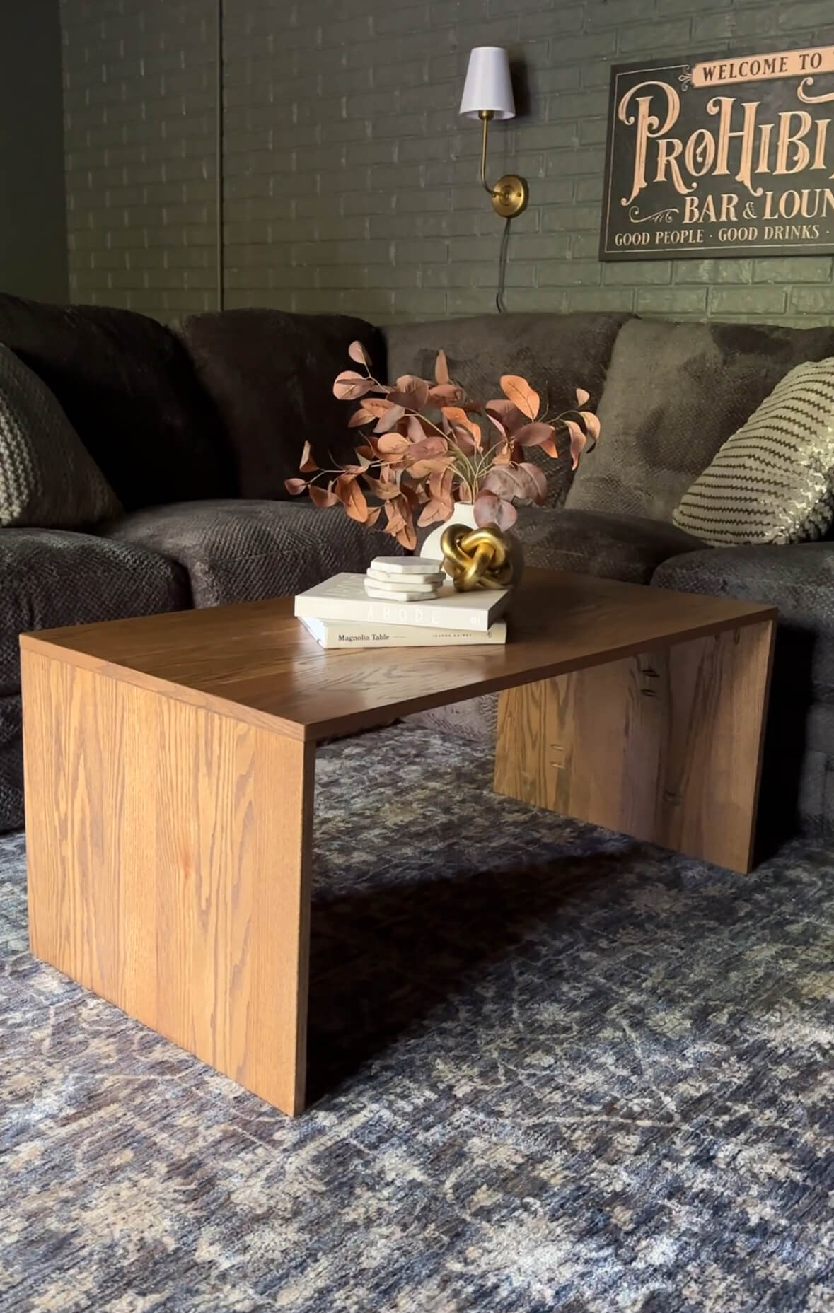 A wooden table in a family room with decor arranged on top.