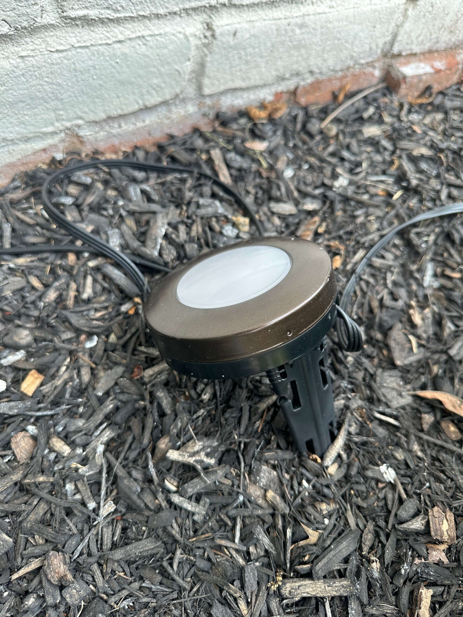 Close-up of Wi-Fi landscape lighting installed by an outdoor wall.