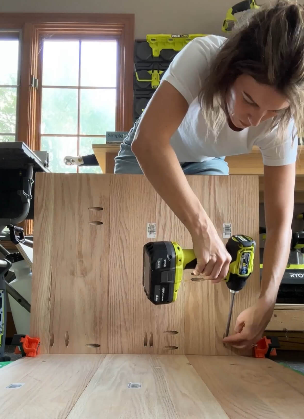 Melissa Tyler using a screwdriver to attach two pieces of project wood together.