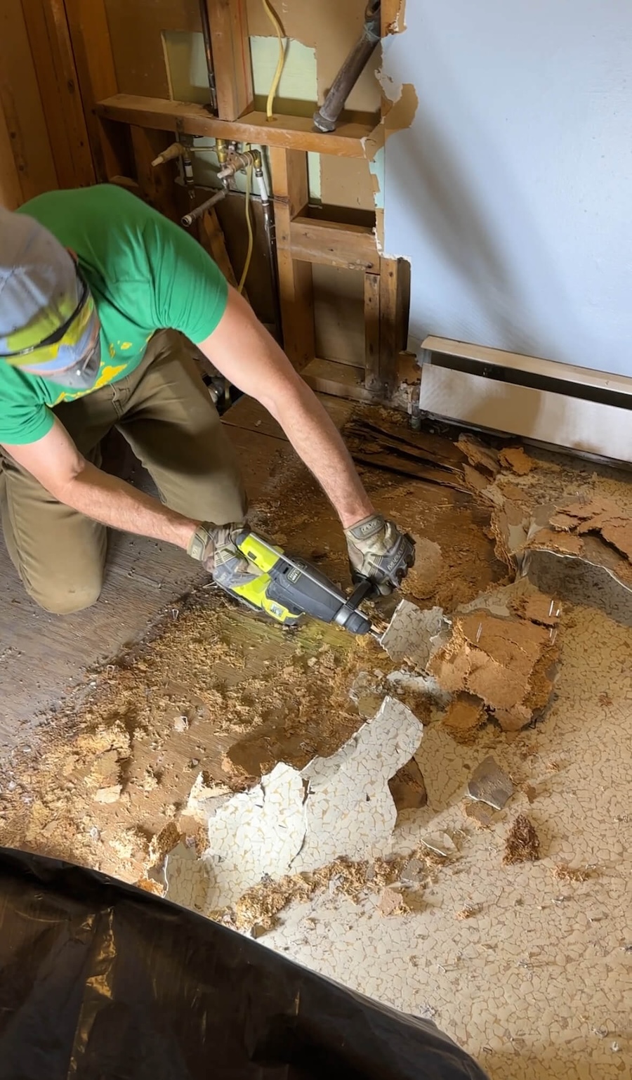 Cody removing the linoleum floor using a hammer drill. 