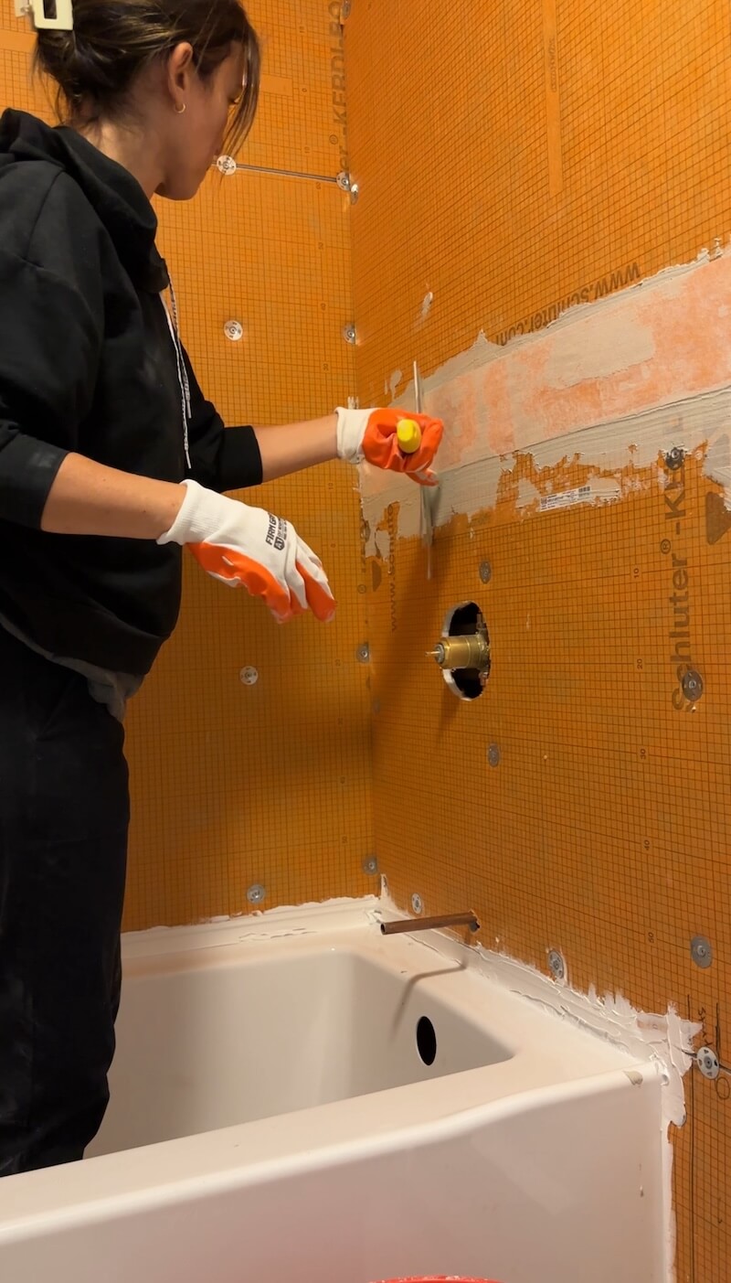 Melissa Tyler using silicone to patch any seams in the kerdi board by using kerdi bands and thin set. 