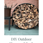 Close up of DIY outdoor firewood rack against a brick wall.