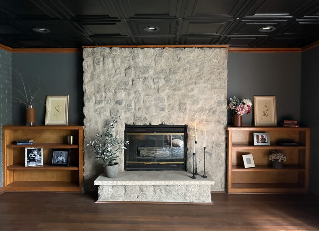 View of the fireplace with completed basement drop ceiling.