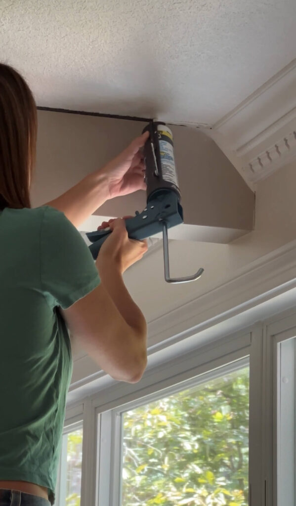 Melissa Tyler caulking the wooden beams.