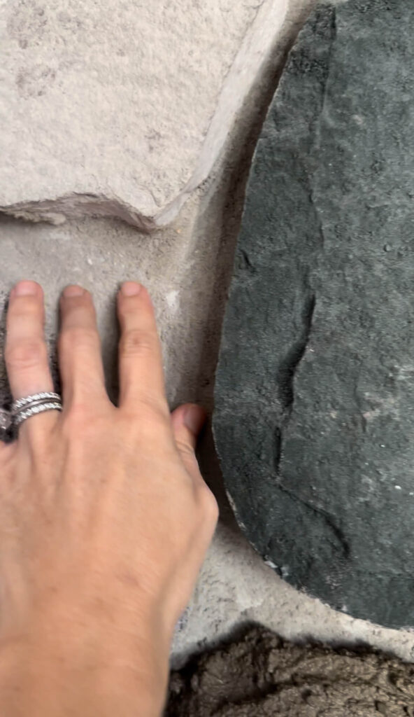 Melissa Tyler's hand fitting in between her fireplace stones.